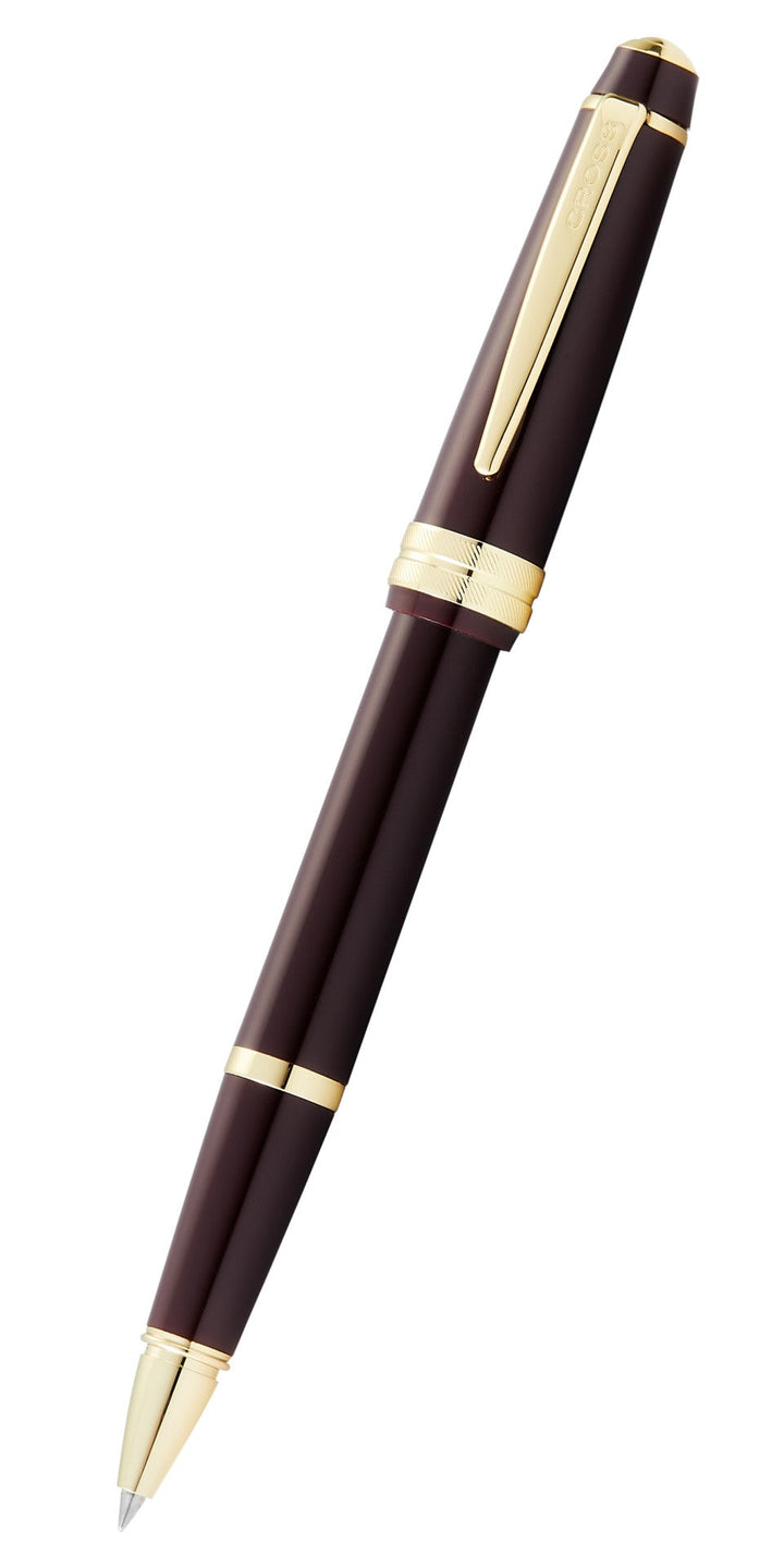 Burgundy resin rollerball pen with gold-tone cap and clip, angled view