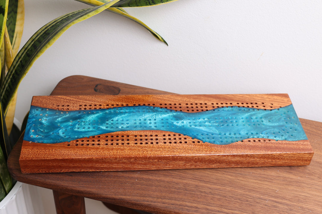Handcrafted river cribbage board in walnut with blue resin inlay and scoring holes
