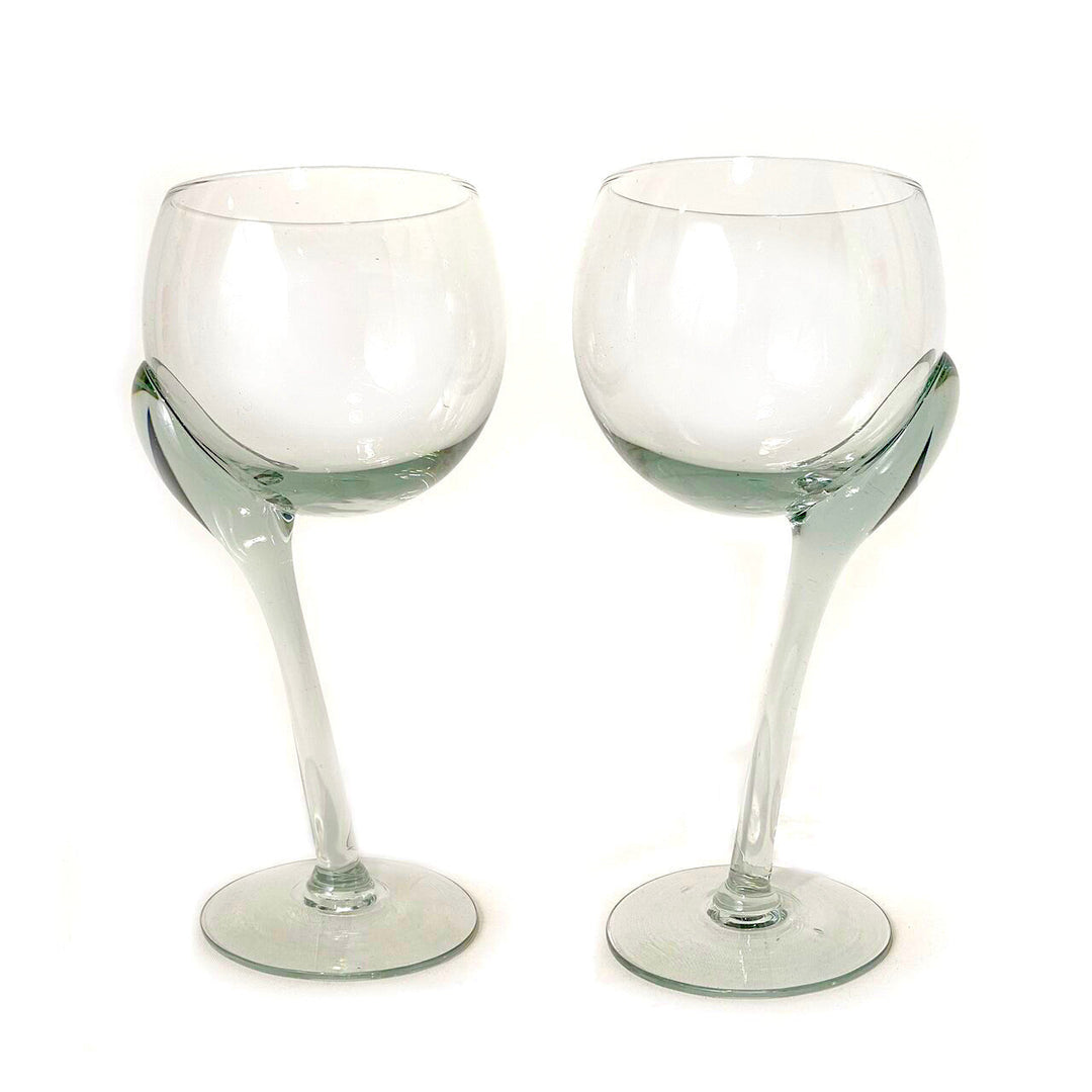 Two crooked-stem wine glasses with green-tinted lower bowls and round bases.
