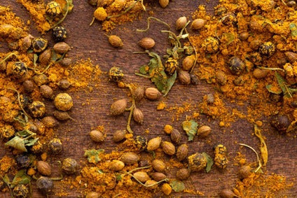 Turkish curry seasoning blend with whole spices and herbs scattered.