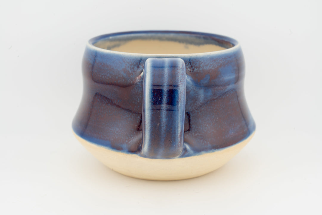 Ceramic wide mug with deep blue glaze, front view with central spout ridge