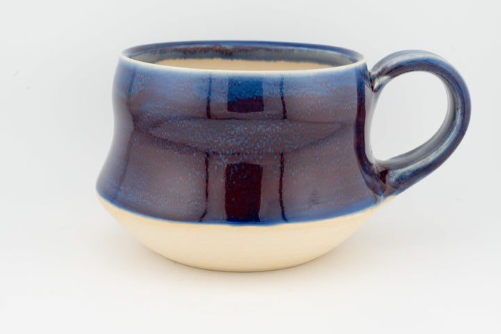 Ceramic wide mug with deep blue glaze, rounded handle and mottled textured finish