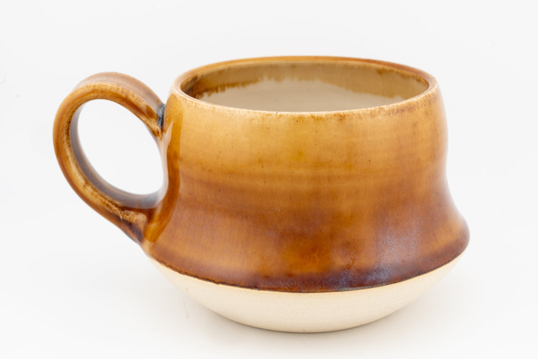 Wide ceramic mug with tan-gold glaze and loop handle, glossy surface