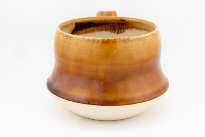 Wide ceramic mug with inside-brown glaze and golden exterior, smooth curved shape