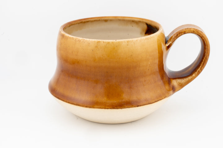 Wide ceramic mug with golden-brown glaze and rounded handle, glossy finish