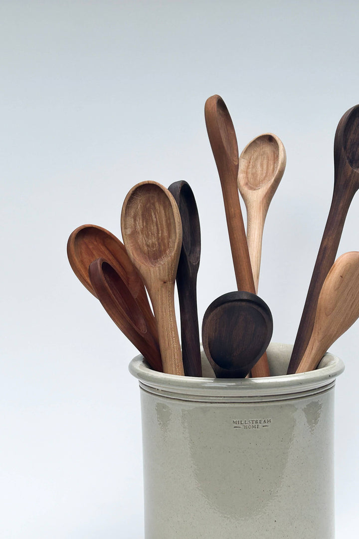 Handcrafted wooden cooking spoons in a jar, varied wood tones