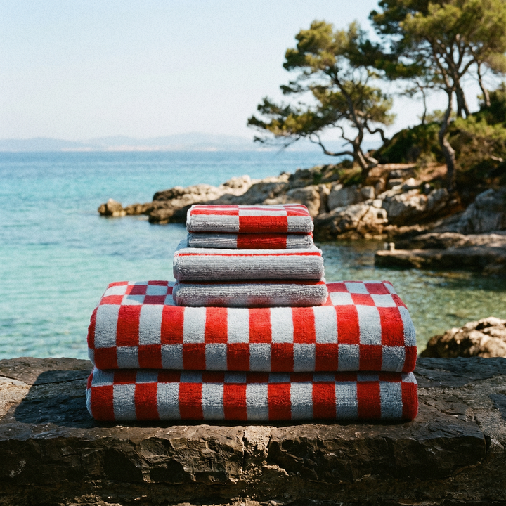 Stacked cotton towels with red-and-white check border and gray terry layers