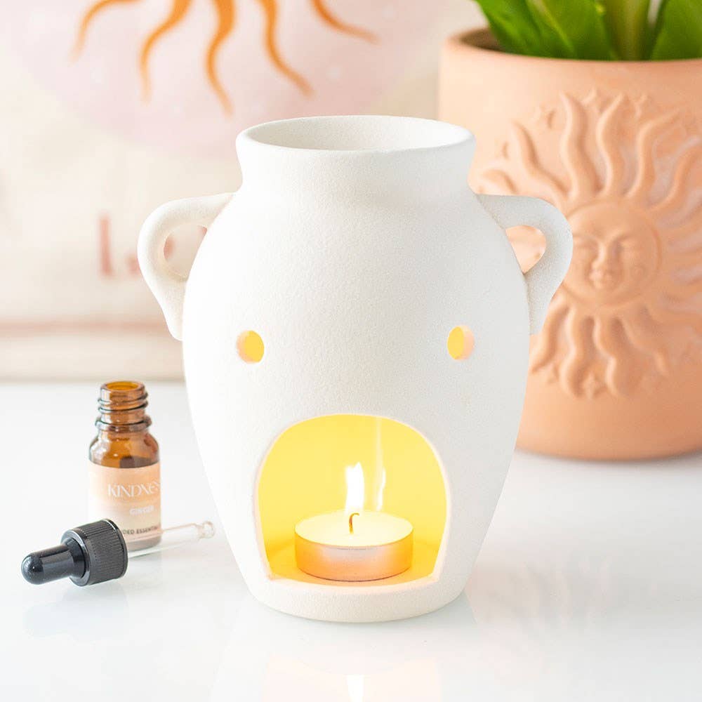 White vase-shaped oil burner and wax warmer with side handles and lit tealight