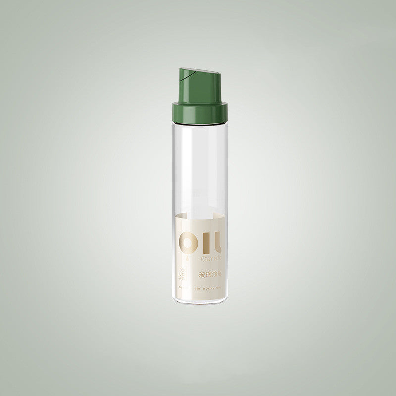 Clear glass oil dispenser bottle with dark green cap