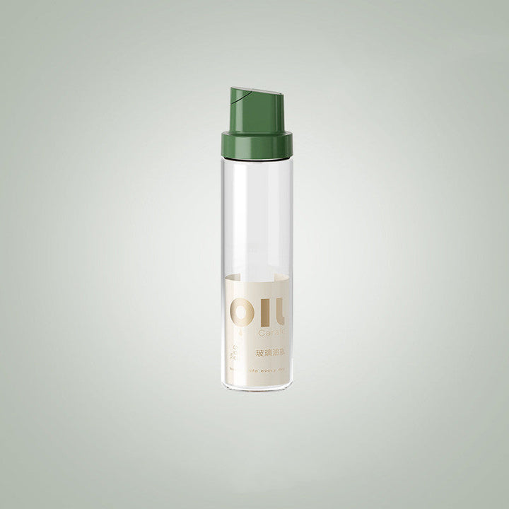 Clear glass oil dispenser bottle with dark green cap