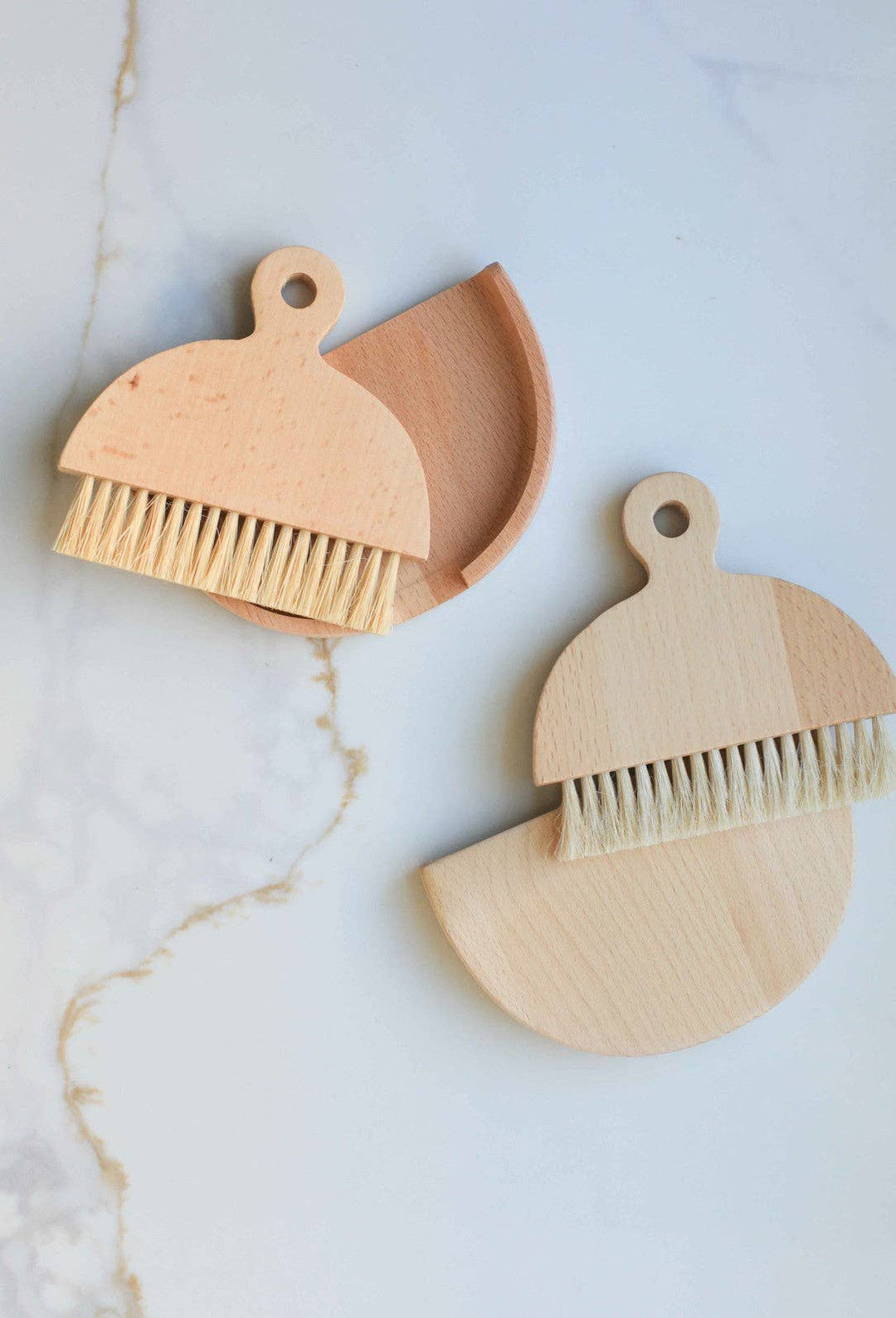 Two wooden table brushes with loop handles and tan bristles