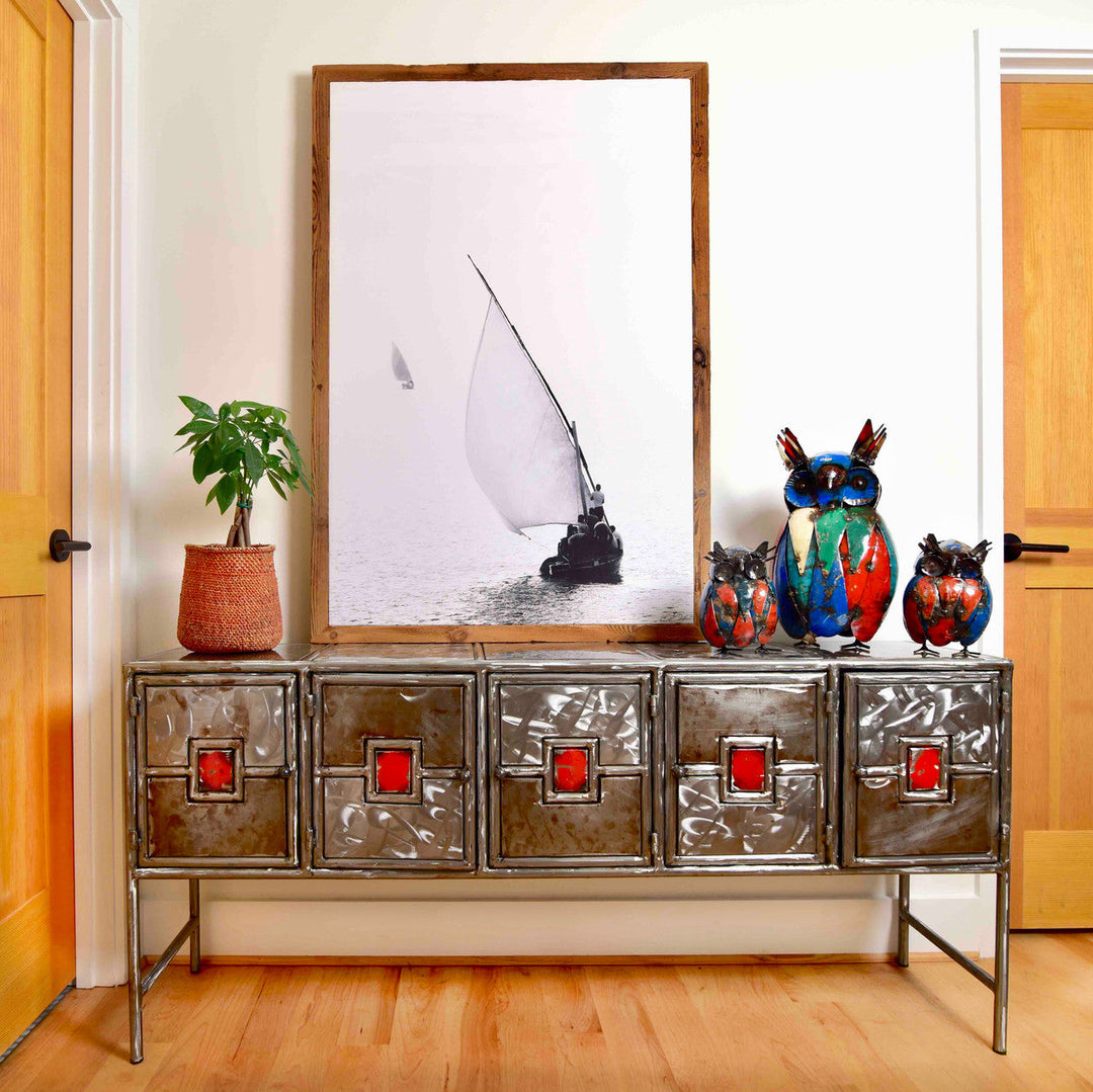 Metal credenza with five drawers and red square insets, open base, distressed silver.