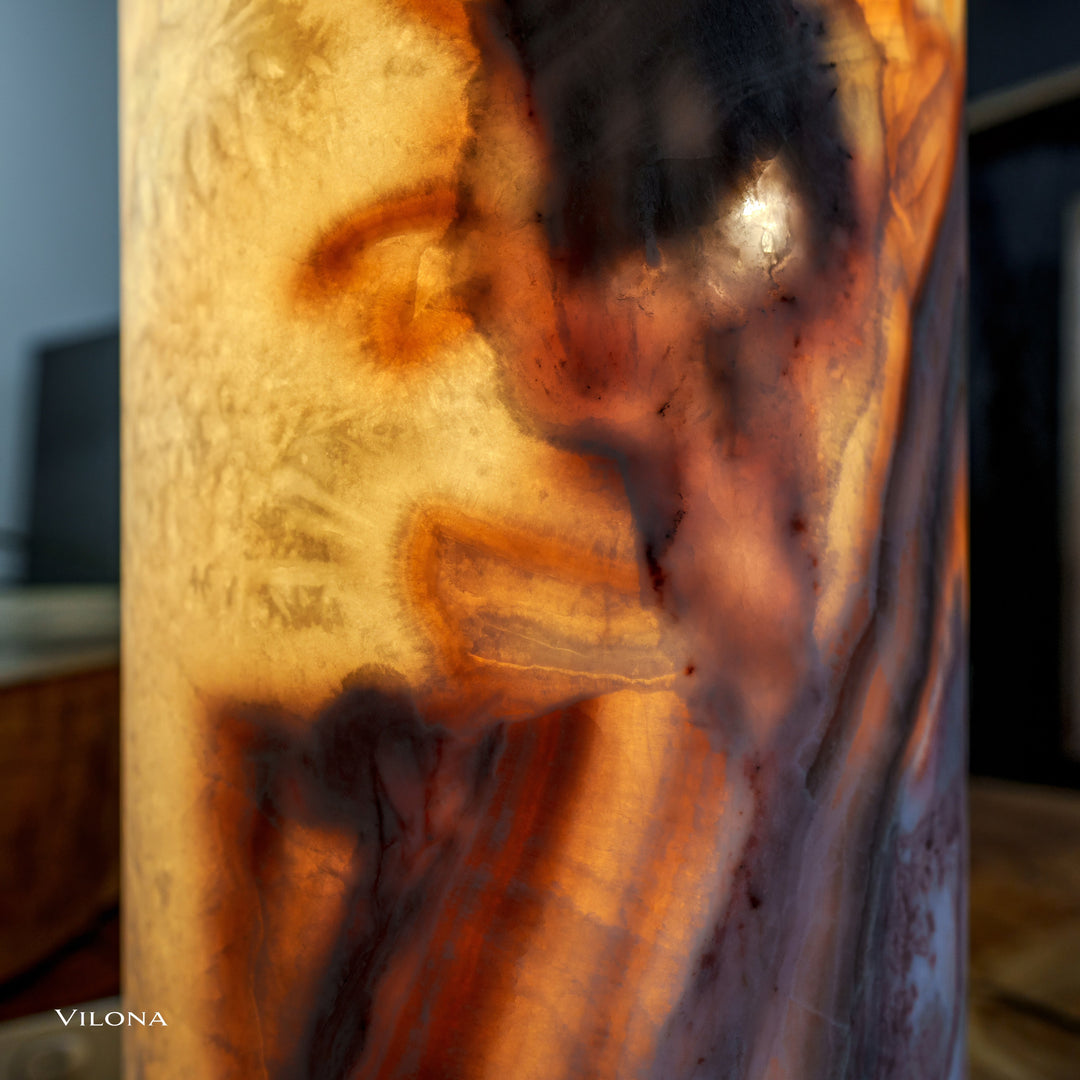 Onyx table lamp close-up: marbled amber, brown, and gray streaks in shade