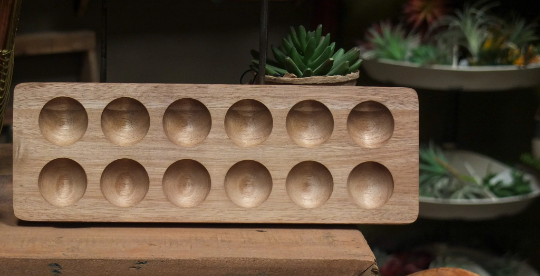 Natural wooden egg tray with 12 circular compartments, angled view