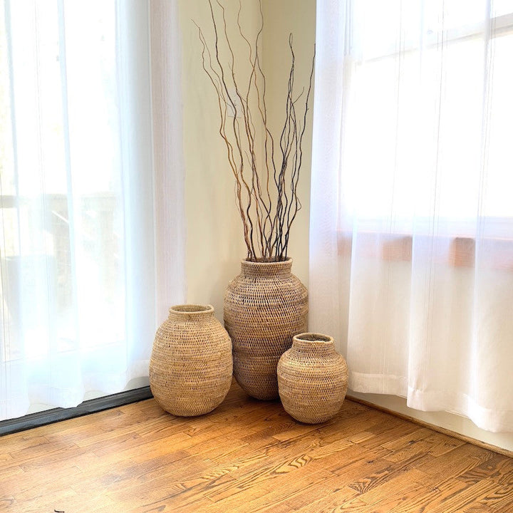 Group of woven jute baskets with tall vase and two smaller round pots