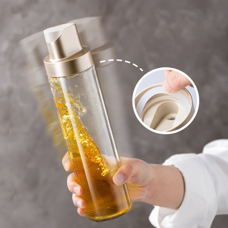 Clear glass oil dispenser bottle with open cap and gravity-flow nozzle