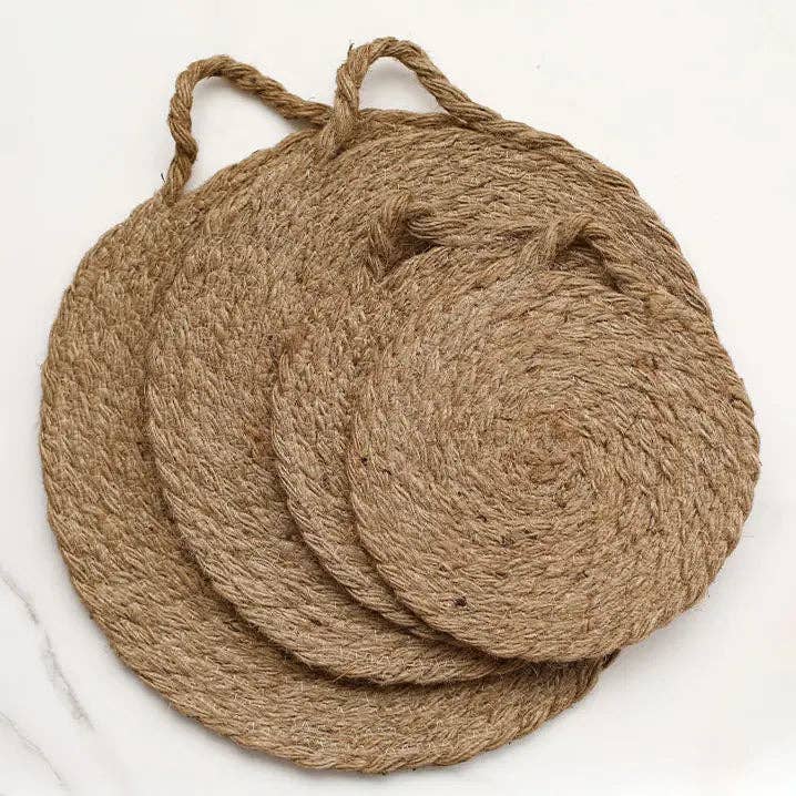 Round woven natural trivet with curled handle loop, close-up view