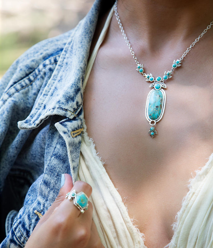 Sterling silver pendant necklace worn with oval blue turquoise centerpiece and round turquoise beads