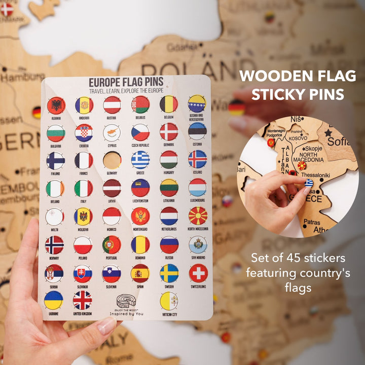 Wooden flag sticky pins set with country-flag stickers; hand places a pin