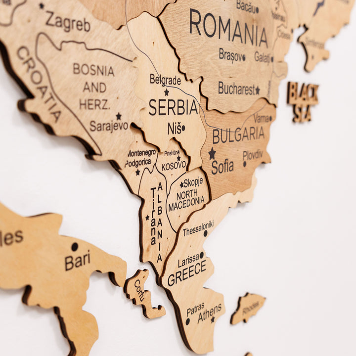 Close-up of gold wooden map featuring Romania, Serbia, Bulgaria, and Greece regions