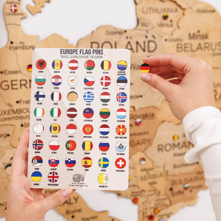 European flag pins card with circular flag designs; hand holds a pin