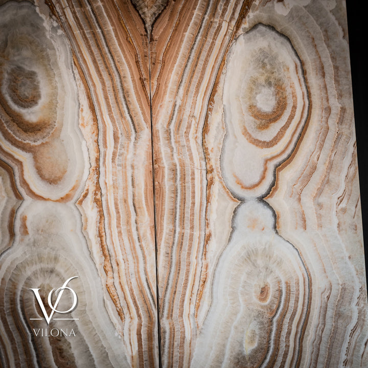 Sahara onyx wall panel detail with white and tan bands, mottled edges, and oval geodes.