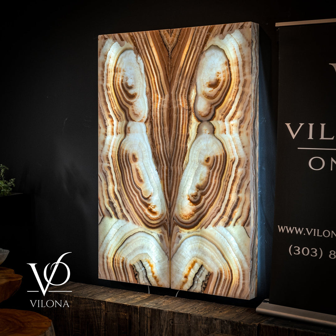 Sahara onyx wall panel with cream ovals, tan stripes, and rounded stone patterns on two panels.