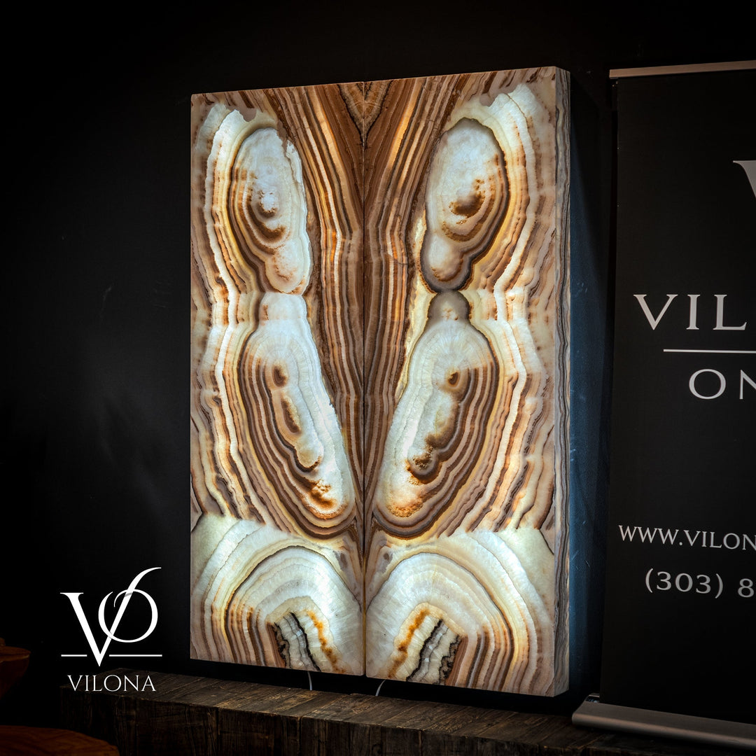 Sahara onyx wall panel featuring cream ovals, tan vertical stripes, and dark mineral veining.