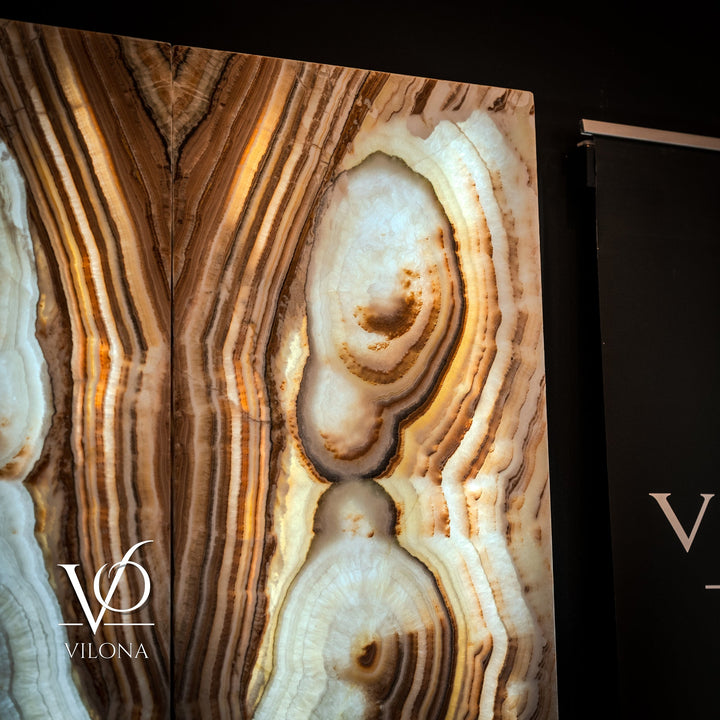 Sahara onyx wall panel close-up with cream and tan striped bands and round geode insets.
