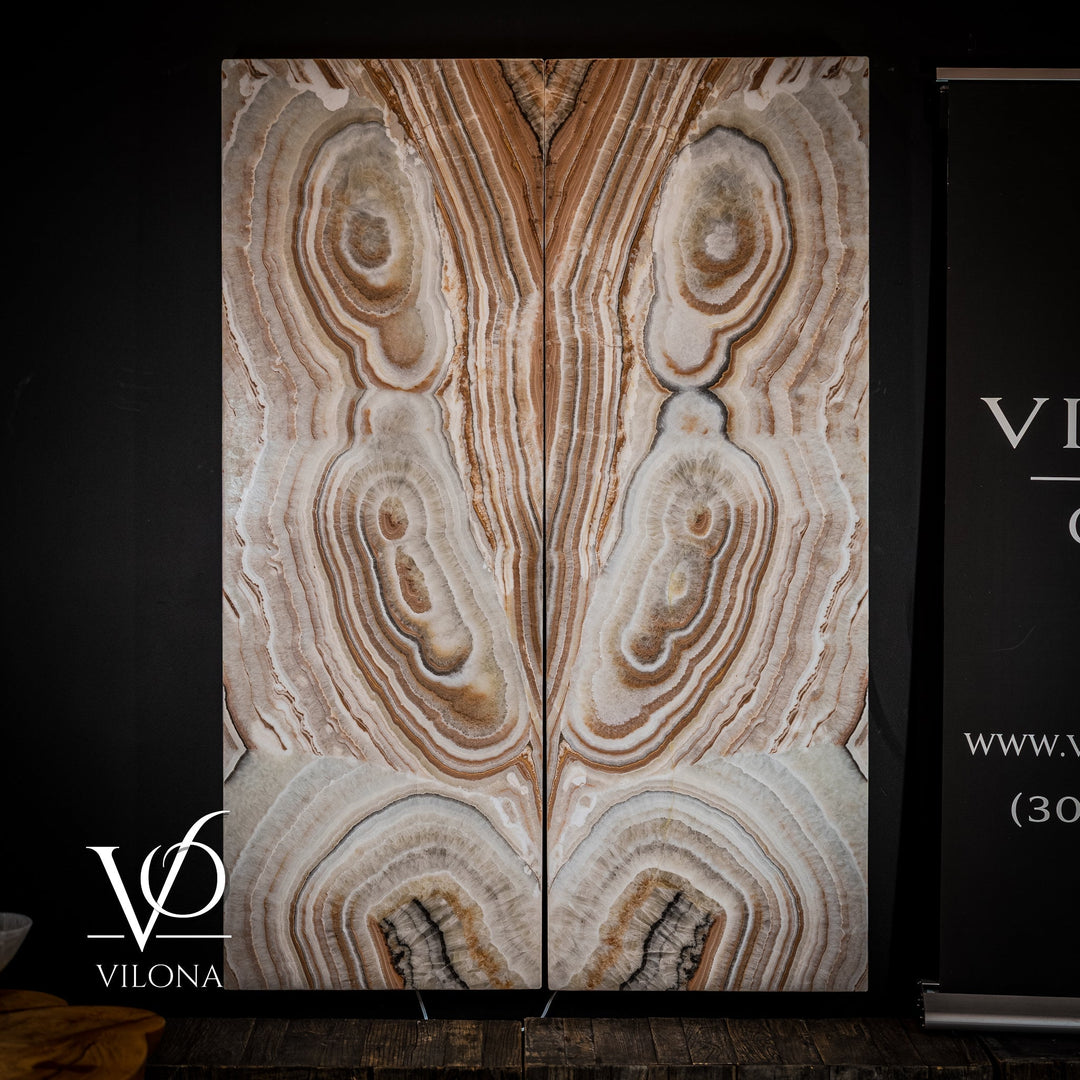 Sahara onyx wall panel showing cream-and-tan striped veining and multiple circular geode details.