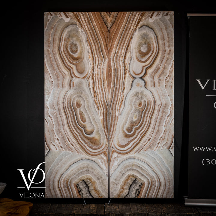 Sahara onyx wall panel showing cream-and-tan striped veining and multiple circular geode details.