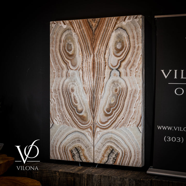 Sahara onyx wall panel with light cream base, tan stripes, and layered oval stone clusters.