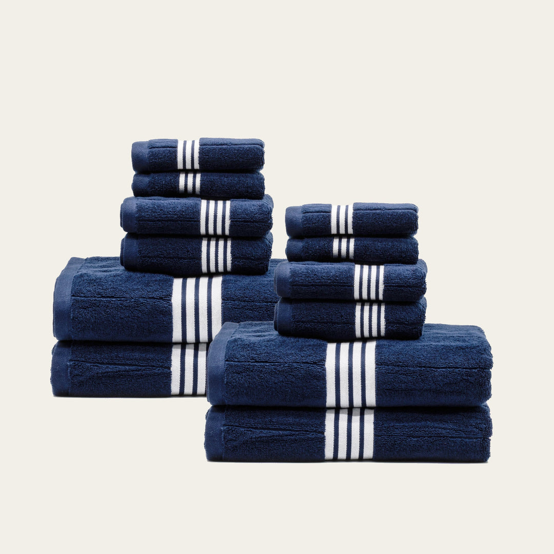 Navy cotton towel set with white striped bands, mixed stacks of 5 towels