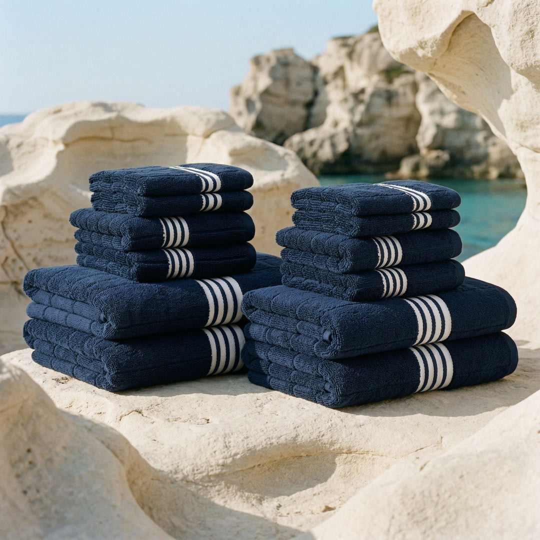 Two stacks of navy cotton towels with white striped bands, neatly folded