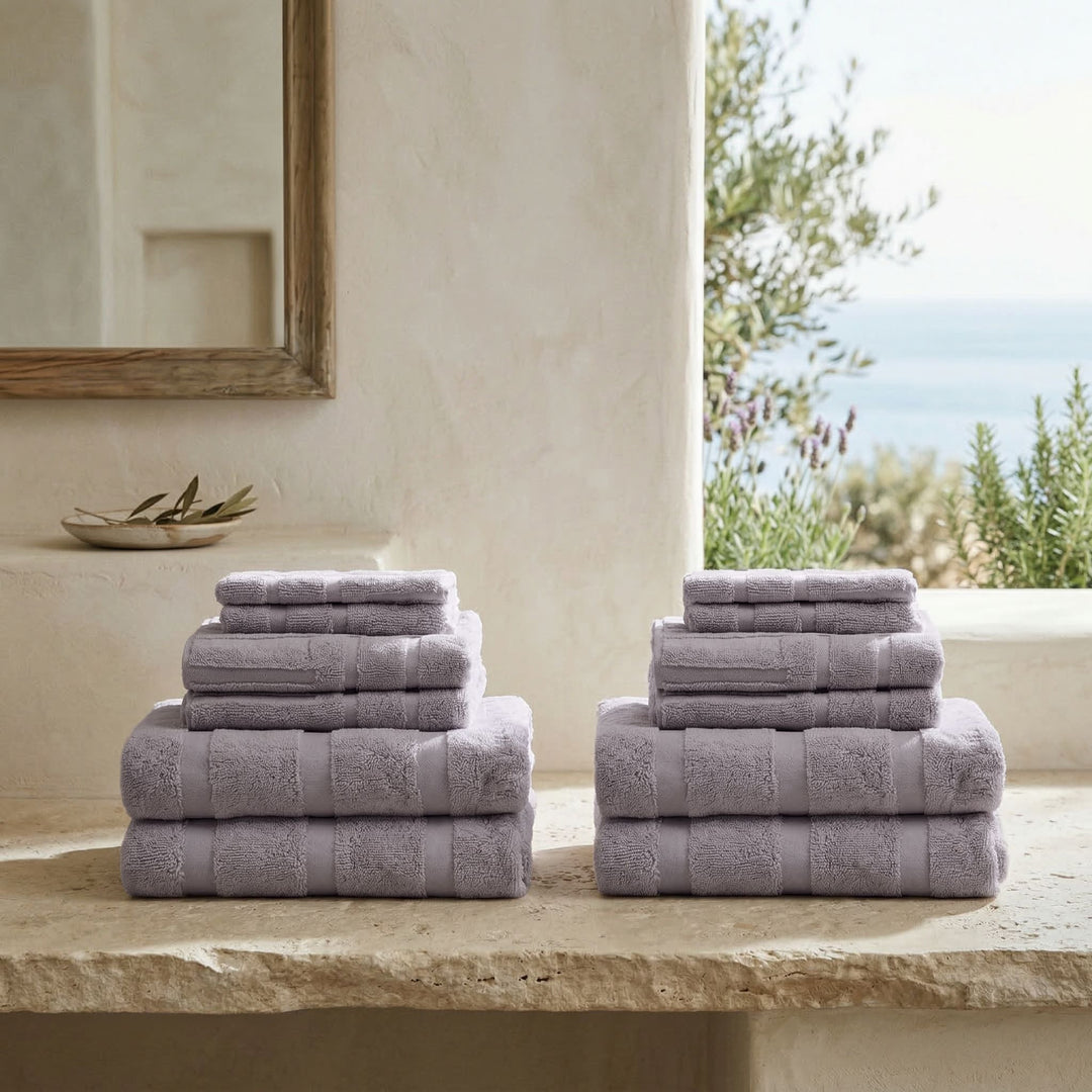 Lilac cotton towels stacked in neat piles with folded hand and bath towels