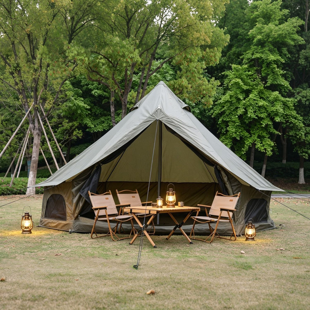 Oxford bell tent with light beige outer fly and dark inner canopy, table and lantern lights.