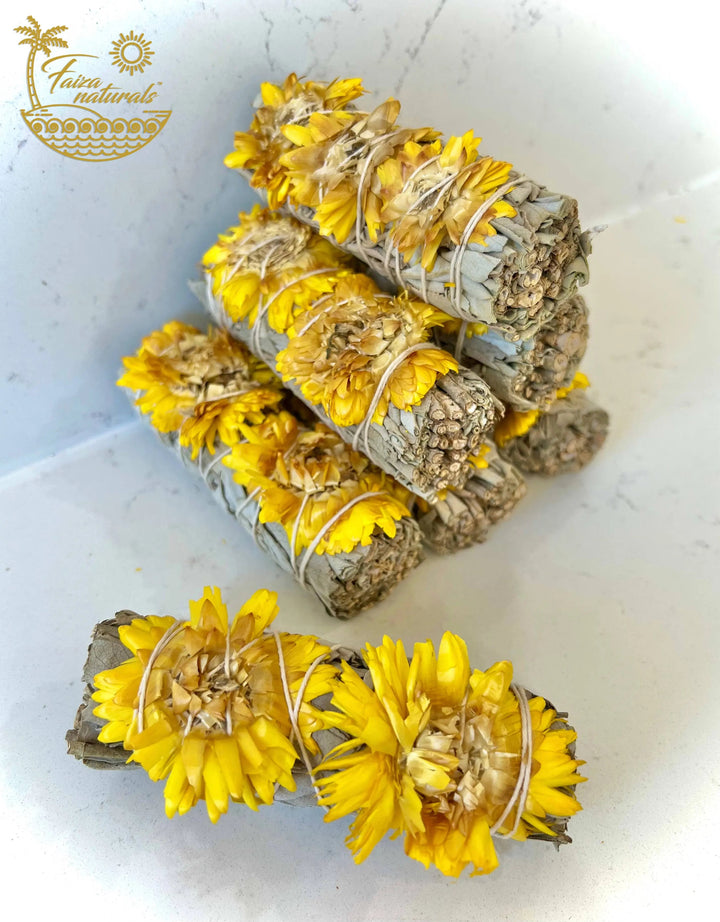 Sunflower and white sage smudge bundle with yellow blooms, tied with twine