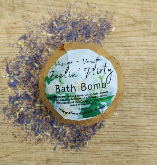 Jasmine vanilla bath bomb on kraft label, with purple dried flower sprinkles