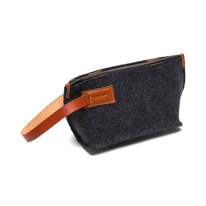 Charcoal felt travel pouch with tan leather strap, zipper, and front leather patch