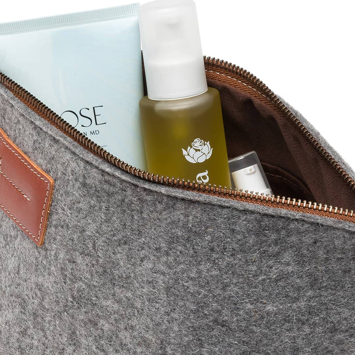 Gray felt travel kit pouch interior with toiletry bottles and gold zipper