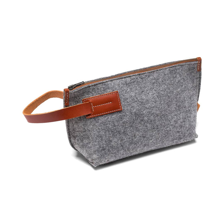 Gray felt travel pouch with tan leather strap, zipper top, and front leather patch
