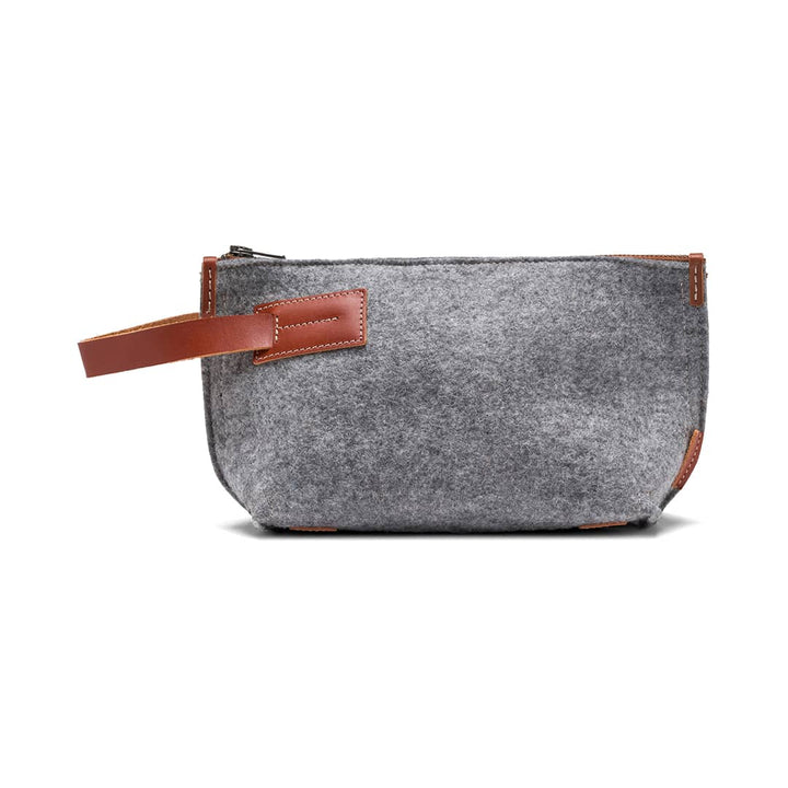 Gray felt travel kit pouch with tan leather handle and side zipper trim