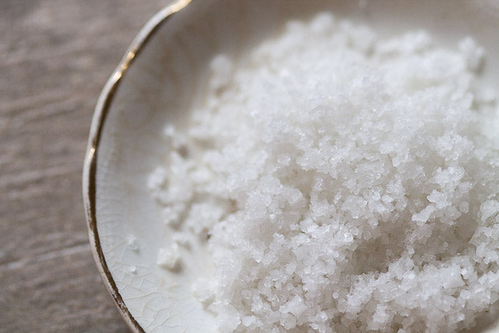 Fleur de Sel sea salt flakes in a spoon, coarse crystal texture