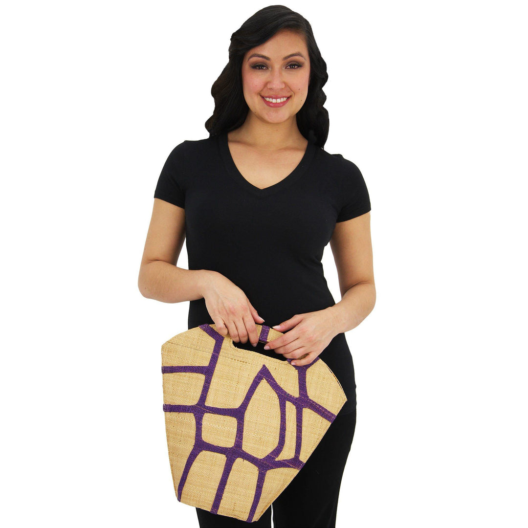 Raffia bag with purple geometric pattern, carried by model with top handle