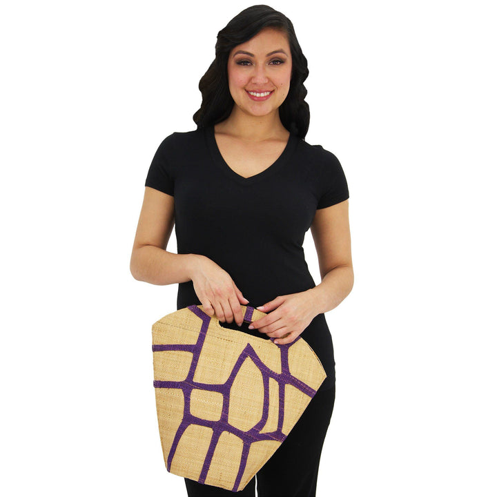 Raffia bag with purple geometric pattern, carried by model with top handle