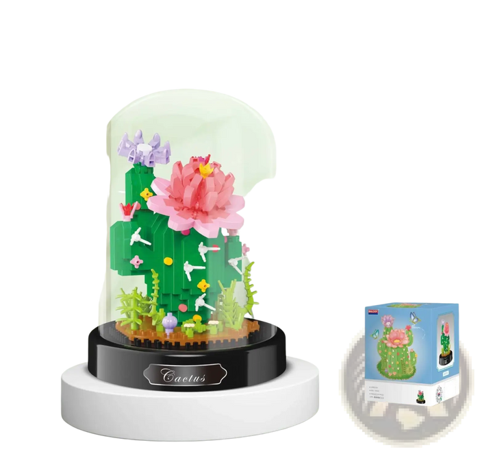 Glass dome floral building block bouquet with pink flower, greenery, and multicolor accents on base