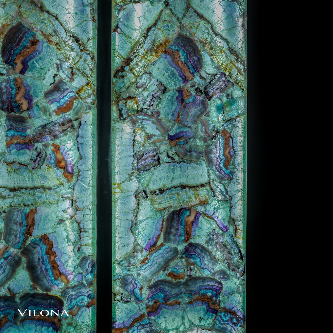Two fluorite crystal wall panels, teal with purple-edged brown inclusions and swirls