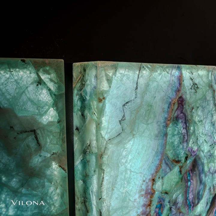 Side-by-side closeup of teal fluorite wall panels with pale veins and purple vertical streak