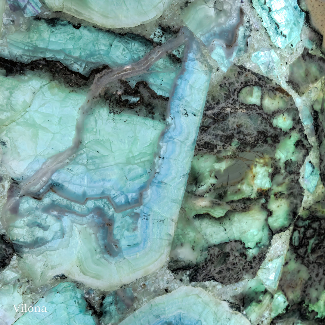Fluorite crystal wall panel close-up with pale turquoise swirls and dark mineral specks