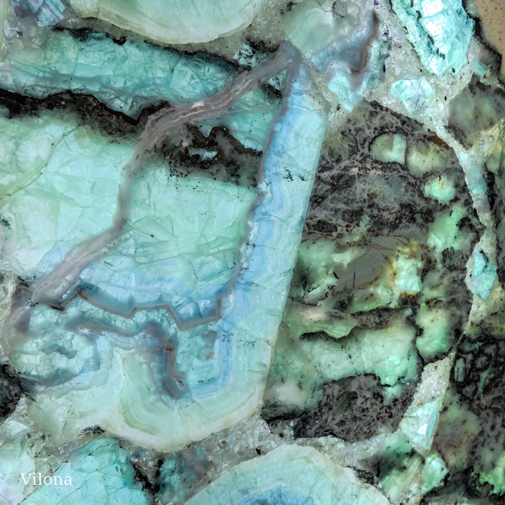 Fluorite crystal wall panel close-up with pale turquoise swirls and dark mineral specks